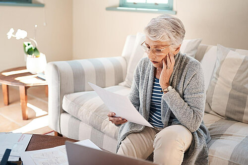 A lady looking at her bills.